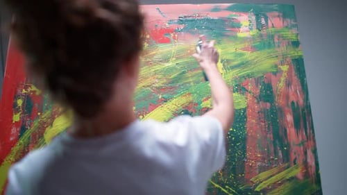 Back View Female Artist Draws with Spray Paint on a Large Canvas in a White Room a Talented Artist