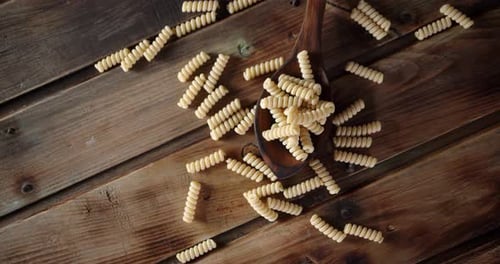 Dry Pasta Fusilli in a Wooden Spoon Slowly Rotates.