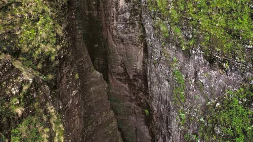 Reibungsloser Drohnenflug aus der tiefen Schlucht zwischen zwei nahe stehenden hohen Felswänden