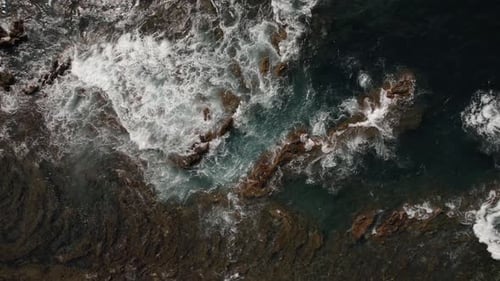 Aerial View of Waves Crushing on Volcanic Coastline