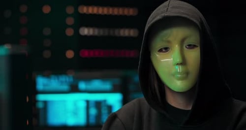 Masked Hacker Working at Computer at Night