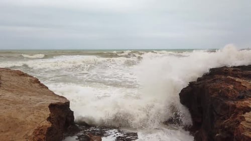 Wasser fließt über die felsige Oberfläche und Wellen bilden weißen Schaum