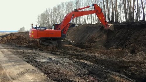 Orange Excavator Digging into Hillside on Sunny Day