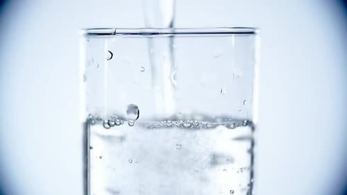 Water Being Poured Into Clear Glass