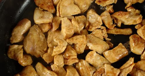 Chicken Pieces Cooking in a Skillet Close Up