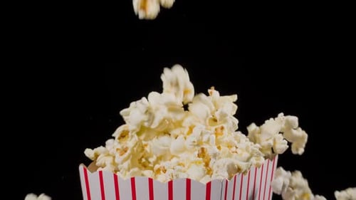 Popcorn falling in slow motion into a popcorn bucket