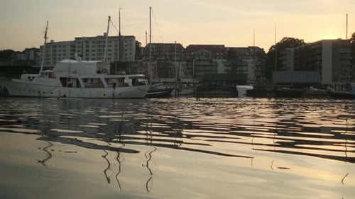 Panning Shot of Boats Docked By the Bay and Houses in Background