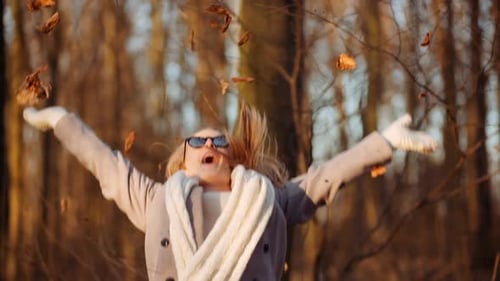 Positive Happy Woman Throwing Leaves in Autumn in Park