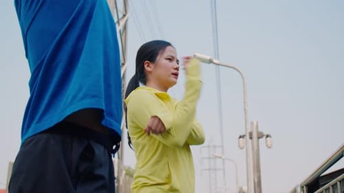 Athletic Couple Stretching Together Outdoors on Sunny Day