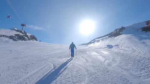 Sunny Winter Day Skiing Uphill on Snowy Mountain