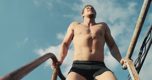 Muscular Man Doing Dips Outside on Metal Structure