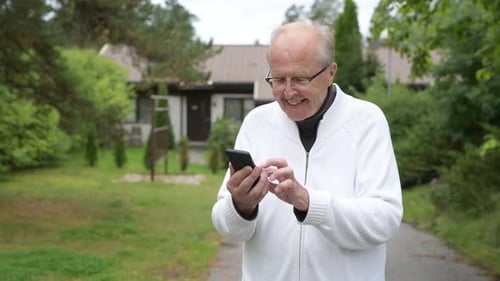 Senior Man Uses Smartphone in Suburban Setting