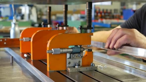 Man Measures Metal with Precise Tool in Factory