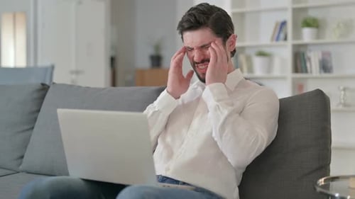 Man Experiencing Headache While Using Laptop at Home