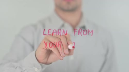 Man Writes Learn from Your Past on Glass