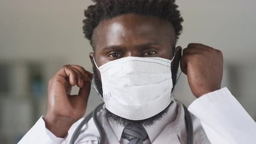 Smiling Doctor Removes Mask After Work