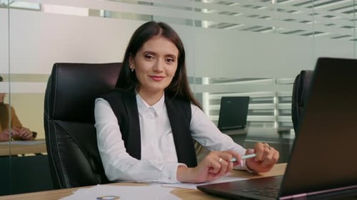 Smiling Woman Working at Desk in Modern Office