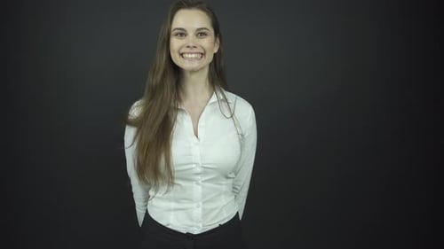 Jolie brune aux cheveux longs sourit et saute avec joie