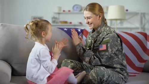 Soldier Woman Playing Hand Game with Child at Home
