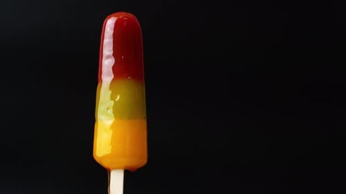 Melting Tri-Color Popsicle on Black Background