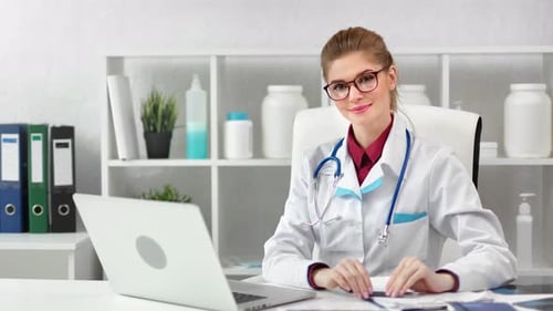 Adorable Happy Female Doctor Posing at White Clinic Office Room Looking at Camera