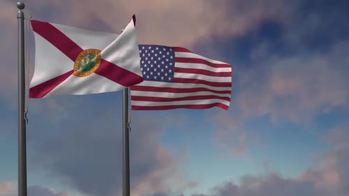 Florida And USA Flags Waving Against Blue Sky
