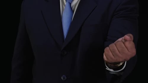 Man in Suit Gesturing with Open Palm and Fist