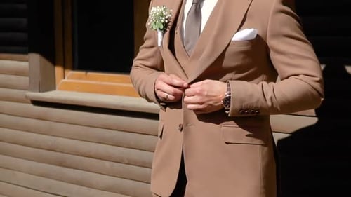 A Successful Young Man Puts on a Suit Brown Jacket