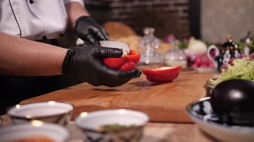 Chef Cuts Red Pepper on Wooden Board