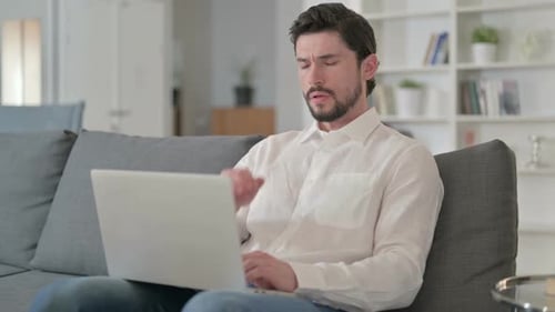 Man with Headache Using Laptop at Home