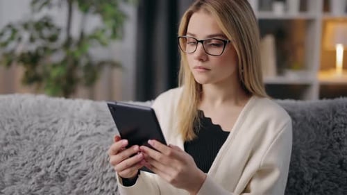 Woman Using Tablet at Home on Couch