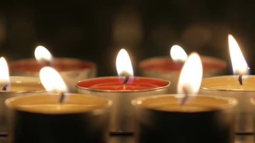 Glowing Candle Flames Flicker in the Darkness