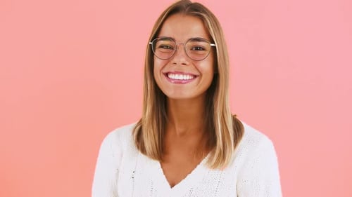 Smiling Woman with Glasses on Pink Background