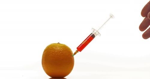 Syringe Injects Red Liquid into Ripe Orange
