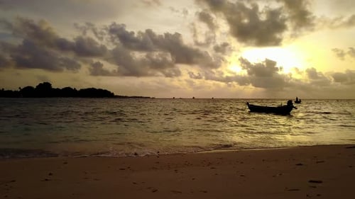 Daytime above tourism shot of a white paradise beach and turquoise sea background in vibrant 4K