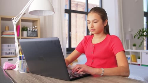 Teen Working on Laptop at Desk in Bedroom