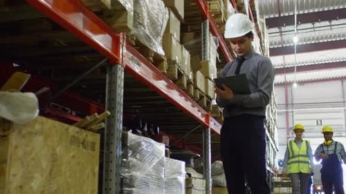 Asian Supervisor Working in Warehouse