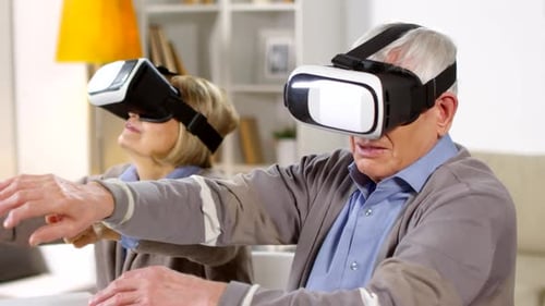 Senior Couple Enjoying Virtual Reality Headsets