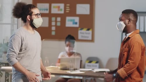Colleagues in Masks Greeting Each Other with Elbow Bump in Office
