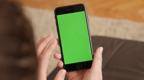 Brunette female at home using green screen display smart phone 4K 2160p 30fps UHD footage - Woman wi