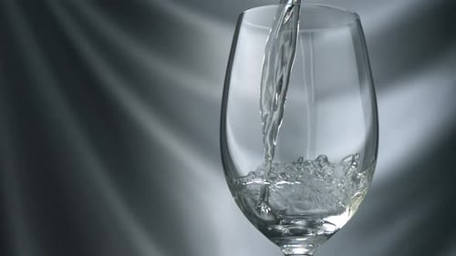 Pouring Clear Liquid into a Wine Glass