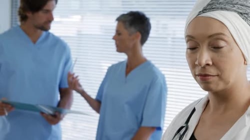 Female Doctor in Hospital Examines the Camera