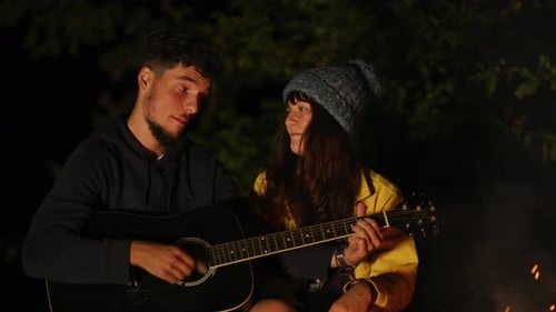Junges Paar singt und spielt Gitarre