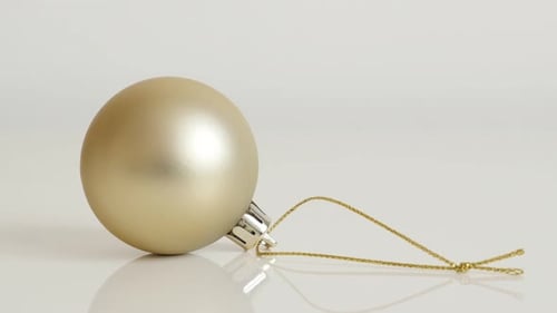 Elegant Golden Christmas Ornament on Reflective Surface