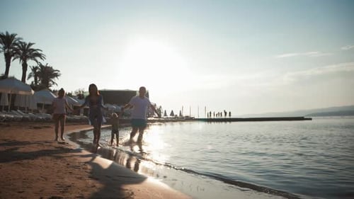 Happy Young Family Have Fun Walking on Beach at Sunset. Family Silhouette Travel Holiday.