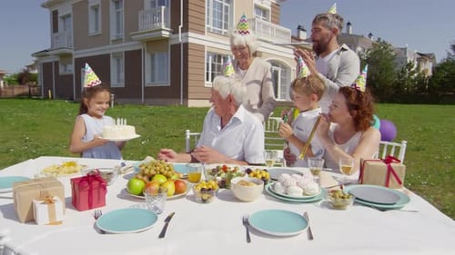 Family Celebrates Birthday Outdoors on Sunny Day