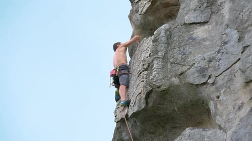Strong Male Climber Climbing Steep Wall of Rocky Mountain