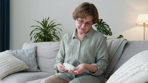 Woman Pours Pills from Bottle into Hand