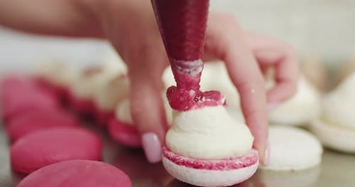 Beautiful Pink Macaroons Fill with Pink Jam on a Pink Background