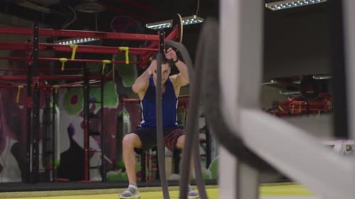 Man Exercising with Ropes in Gym